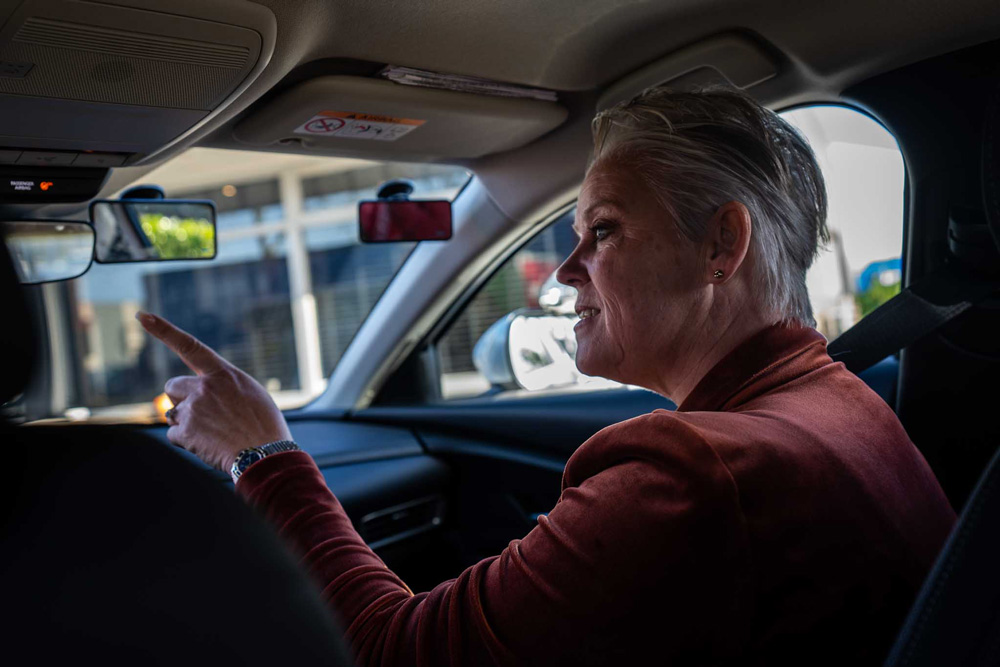 Rij-instructeur geeft aanwijzingen vanaf de bijrijdersstoel tijdens een autorijles